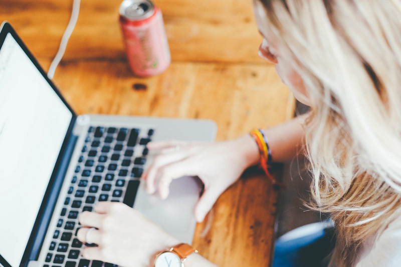 Frau am Laptop mit Trinken